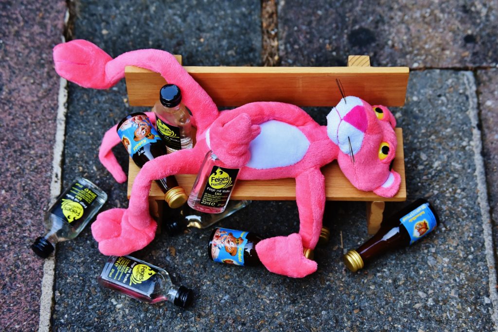 Pink Panther drunk on a bench with empty bottles