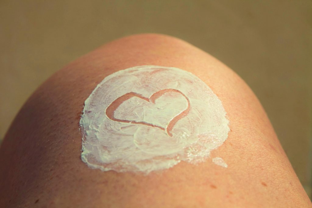 leg with white lotion in the shape of a heart
