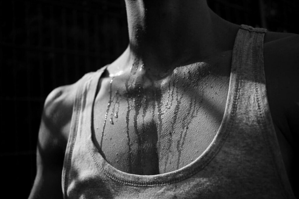 Blackand white photo of a woman's chest with sweat.